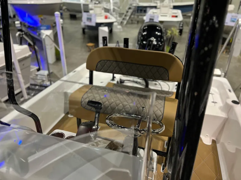 Slide: The Image of 2024 Clearwater 2100 Baystar boat interior with tan and black seating, steering wheel, and controls. - 12