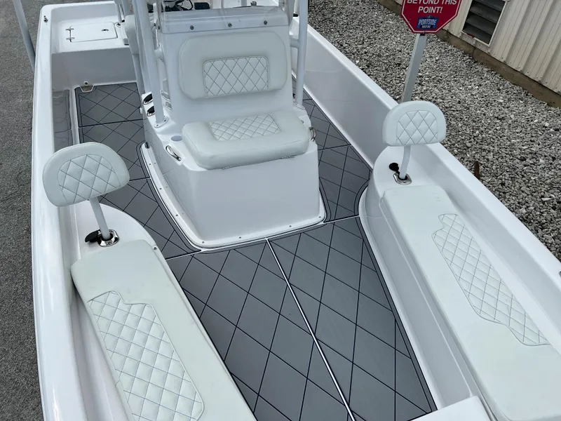 Slide: The Image of 2024 Clearwater 2100 Baystar boat interior with white cushioned seats and gray flooring. - 10
