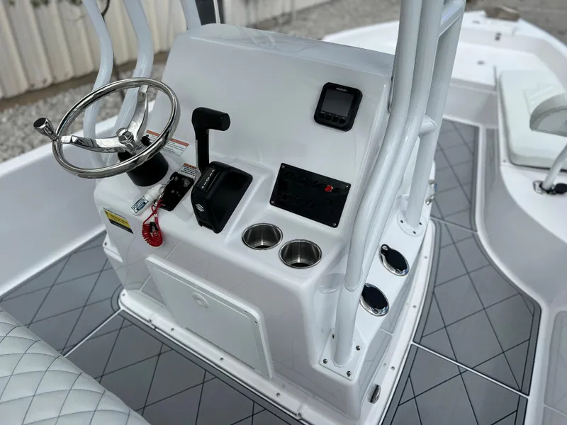 Slide: The Image of 2024 Clearwater 2100 Baystar boat console with steering wheel, controls, and cup holders. - 16