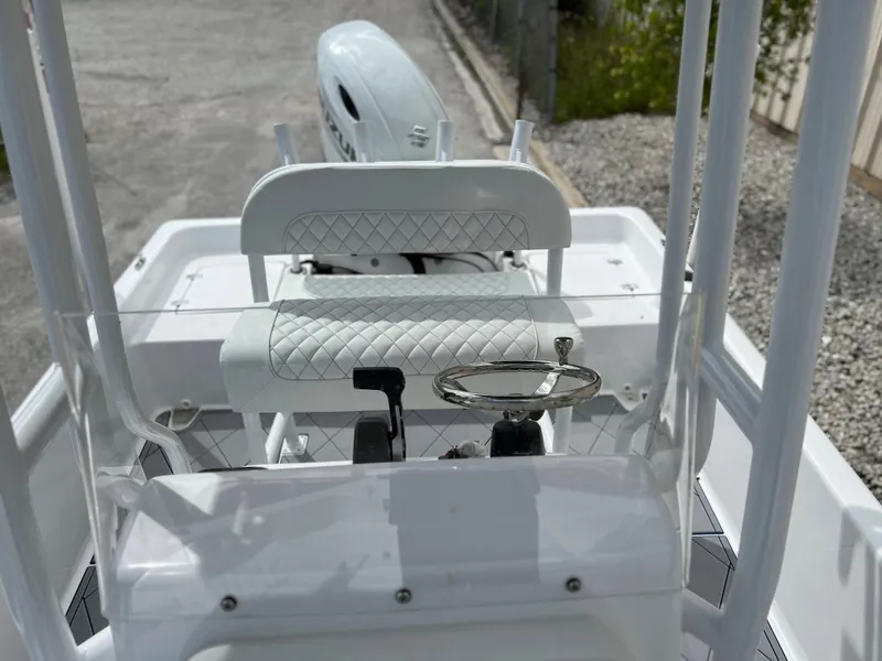 Slide: The Image of 2024 Clearwater 2100 Baystar boat cockpit with steering wheel and cushioned seat. - 19