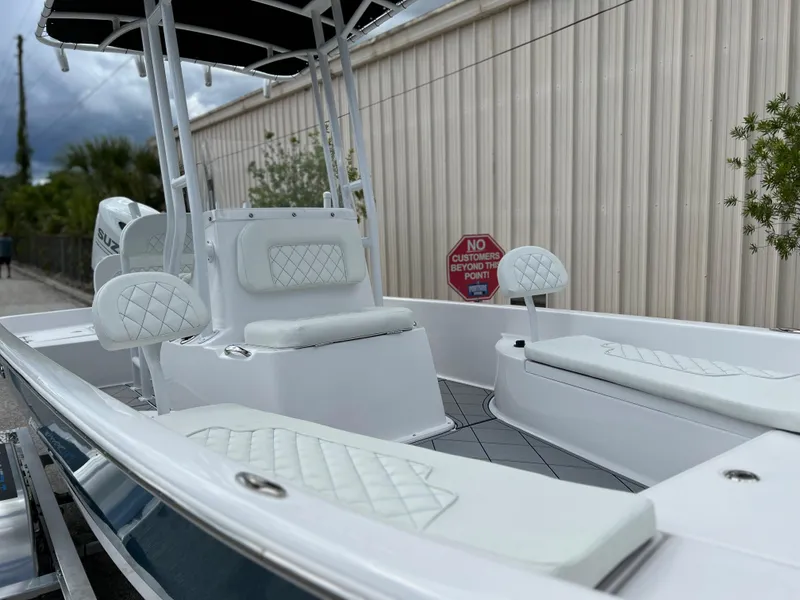 Slide: The Image of 2024 Clearwater 2100 Baystar boat with white cushioned seating and sleek design. - 2