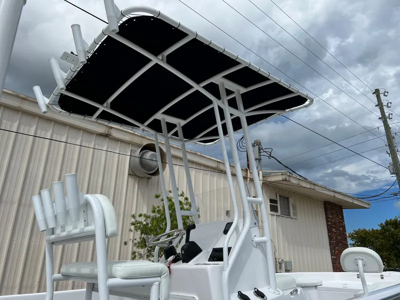 Slide: The Image of 2024 Clearwater 2100 Baystar boat with T-top and seating, parked outdoors. - 25