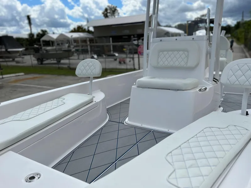 Slide: The Image of 2024 Clearwater 2100 Baystar boat interior with white cushioned seating and diamond-patterned flooring. - 3