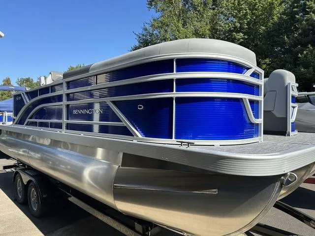 Slide: The Image of 2024 Bennington 20 SVL 3 SPS pontoon boat with blue and silver exterior. - 1