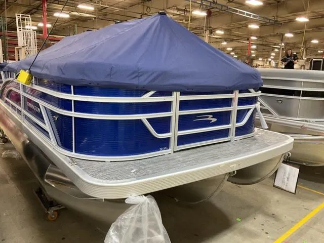 Slide: The Image of 2024 Bennington 20 SVL 3 SPS pontoon boat with blue cover in a warehouse. - 4