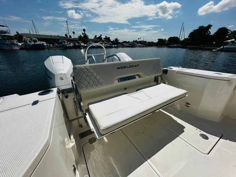 Slide: The Image of 2024 World Cat 260 CC-X boat with foldable seating at the stern, docked in a marina. - 11