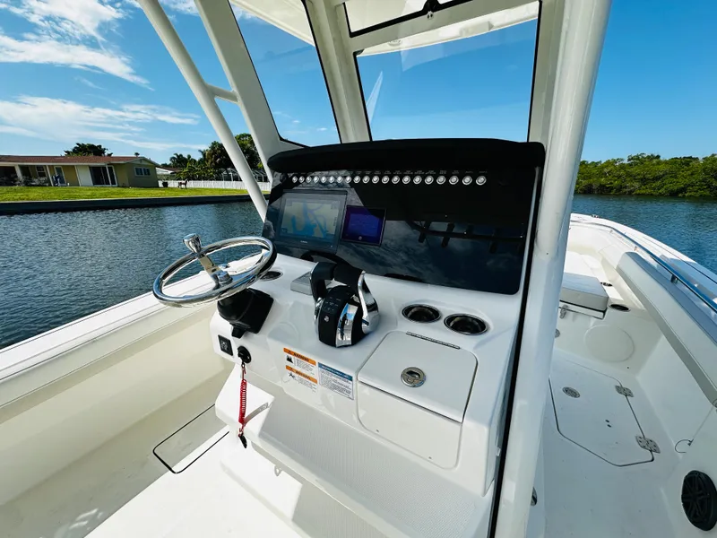 Slide: The Image of 2024 World Cat 260 CC-X boat console with steering wheel and controls. - 16