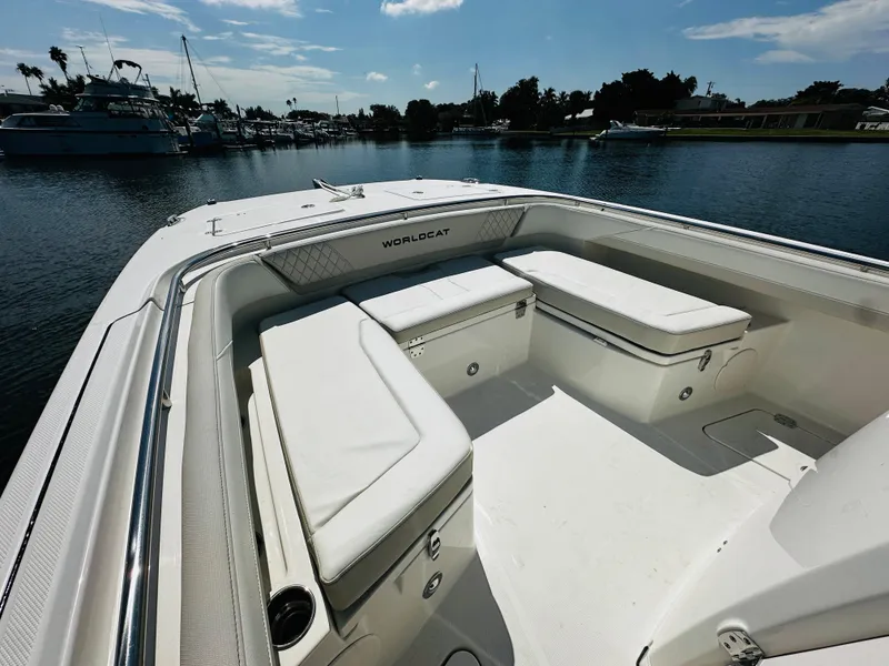Slide: The Image of 2024 World Cat 260 CC-X boat interior with cushioned seating, docked in a marina. - 21