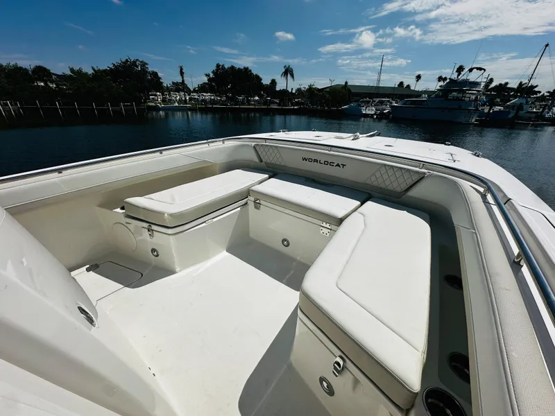Slide: The Image of 2024 World Cat 260 CC-X boat interior with cushioned seating, docked by the water. - 22