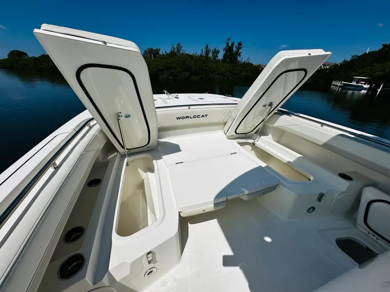 Slide: The Image of 2024 World Cat 260 CC-X boat with open storage compartments on a sunny day. - 24