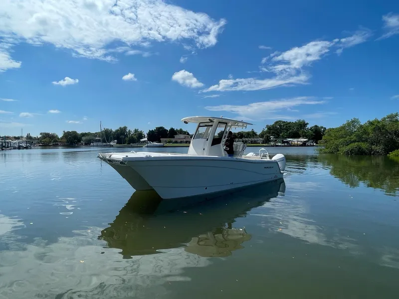 Slide: The Image of 2024 World Cat 260 CC-X boat on calm water under a clear blue sky. - 3
