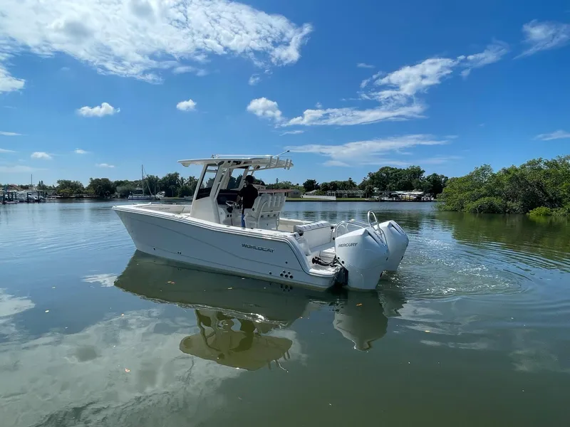 Slide: The Image of 2024 World Cat 260 CC-X boat cruising on a calm lake under a clear blue sky. - 5