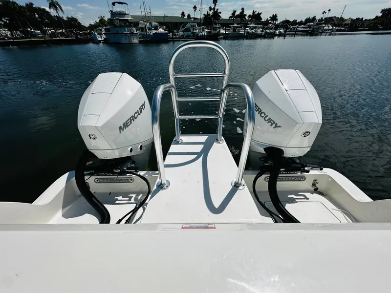 Slide: The Image of 2024 World Cat 260 CC-X boat with twin Mercury engines on a calm marina. - 7