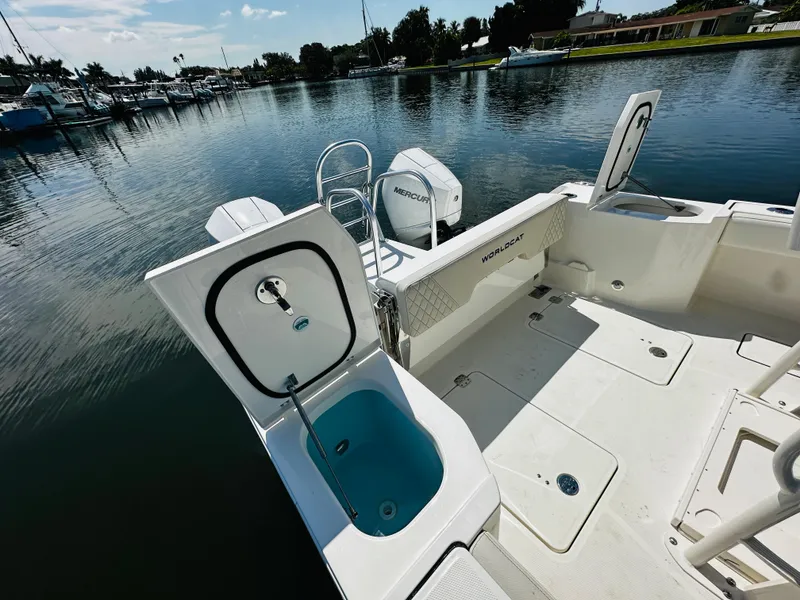 Slide: The Image of 2024 World Cat 260 CC-X boat with open storage compartments docked by the water. - 9