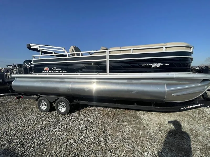 The Image of 2024 Sun Tracker SportFish 22 DLX pontoon boat on a trailer. - 1