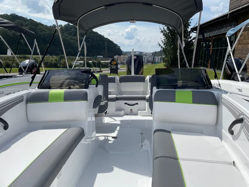 Slide: The Image of 2024 Tahoe T21 boat interior with gray and green seating, under a canopy. - 3