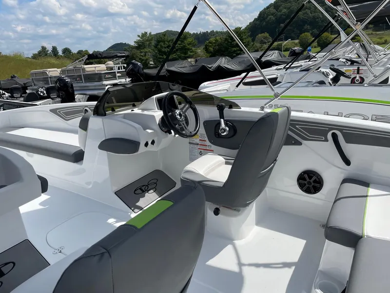 Slide: The Image of 2024 Tahoe T21 boat interior with modern seating and steering wheel, docked under a sunny sky. - 4