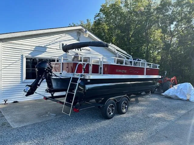 Slide: The Image of 2024 Ranger RP200F pontoon boat on a trailer outside a white building. - 3