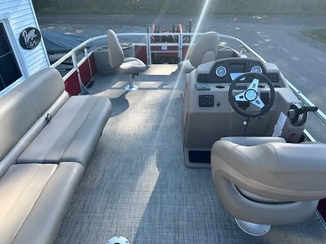 Slide: The Image of 2024 Ranger RP200F pontoon boat interior with beige seating and steering console. - 5