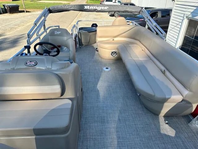 Slide: The Image of 2024 Ranger RP200F pontoon boat with beige seating and spacious deck. - 7