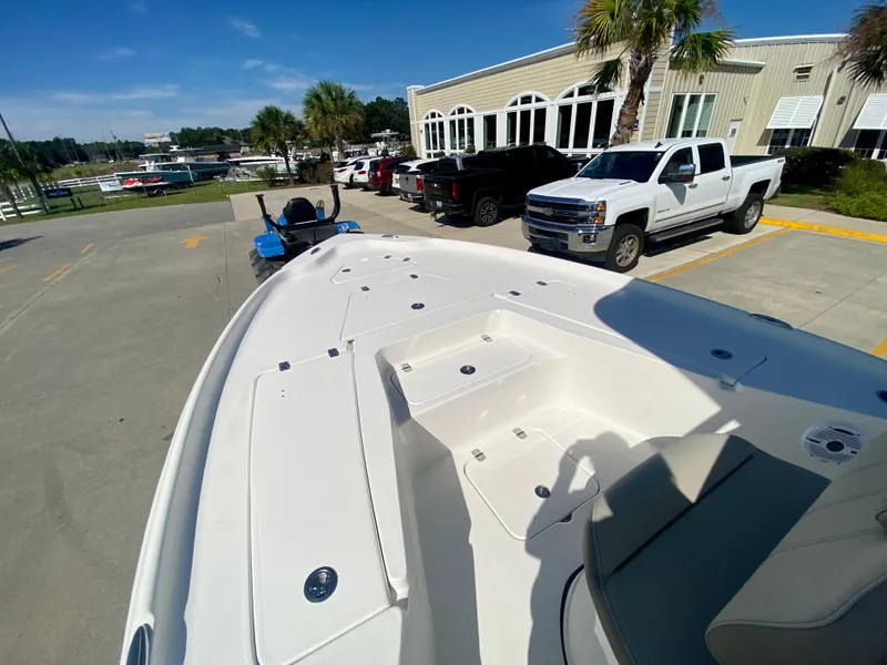 Slide: The Image of 2024 Key West 230 Bay Reef boat at a marina with trucks and palm trees. - 19