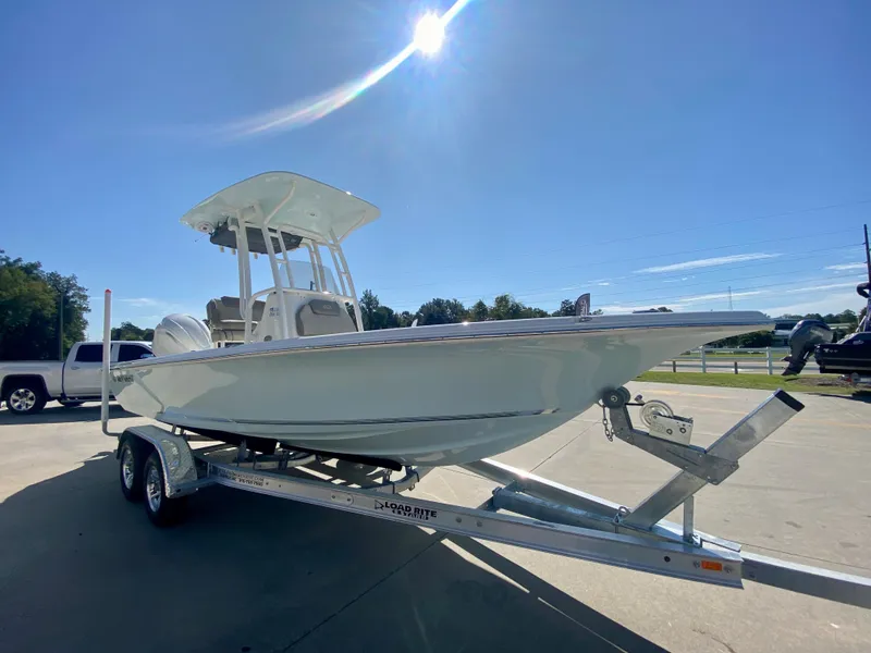Slide: The Image of 2024 Key West 230 Bay Reef boat on a trailer under a clear blue sky. - 2