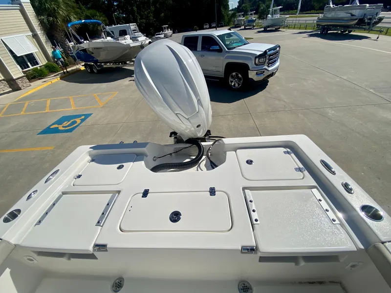 Slide: The Image of 2024 Key West 230 Bay Reef boat with outboard motor in a parking lot. - 6