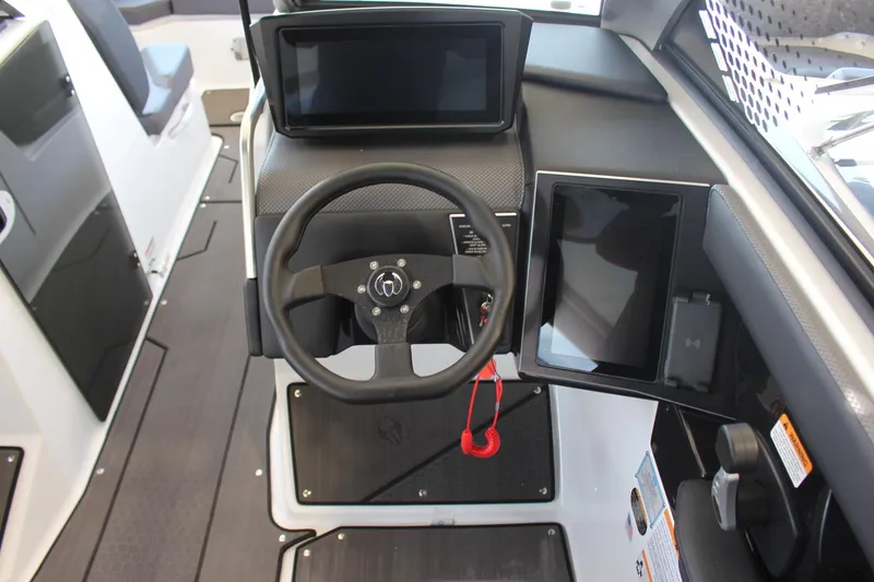 Slide: The Image of 2023 Scarab 285 ID boat cockpit with modern steering wheel and digital displays. - 11
