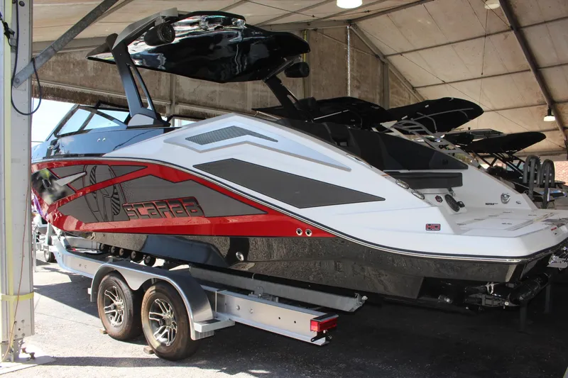 Slide: The Image of 2023 Scarab 285 ID boat on a trailer in a covered storage area. - 2