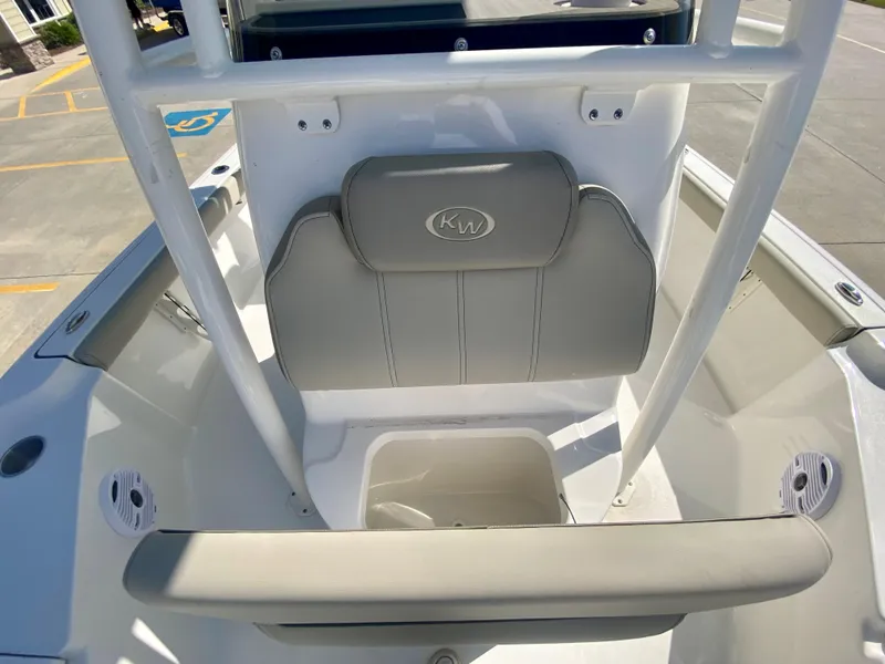 Slide: The Image of 2024 Key West 230 Bay Reef boat interior with cushioned seating and storage compartment. - 21