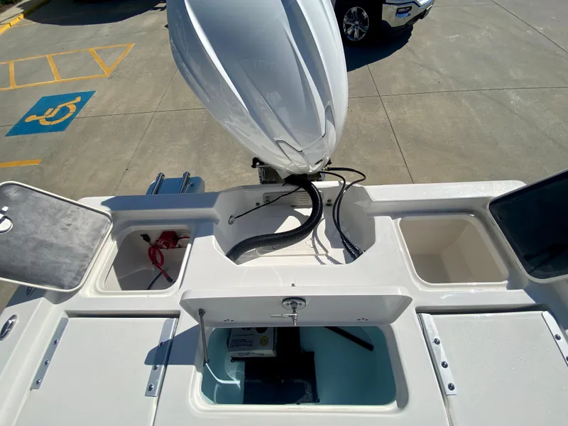 Slide: The Image of 2024 Key West 230 Bay Reef boat stern with open compartments and outboard motor. - 12