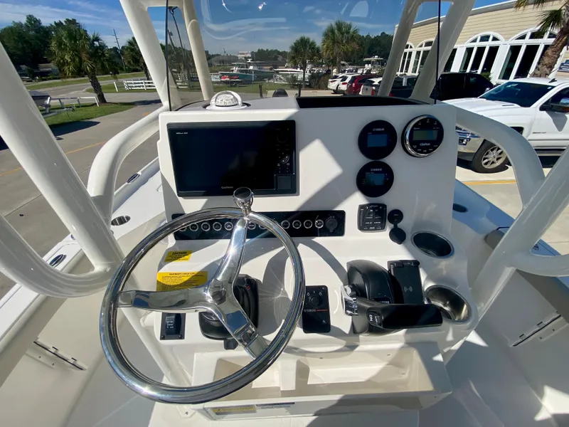 Slide: The Image of 2024 Key West 230 Bay Reef boat console with steering wheel and navigation controls. - 13