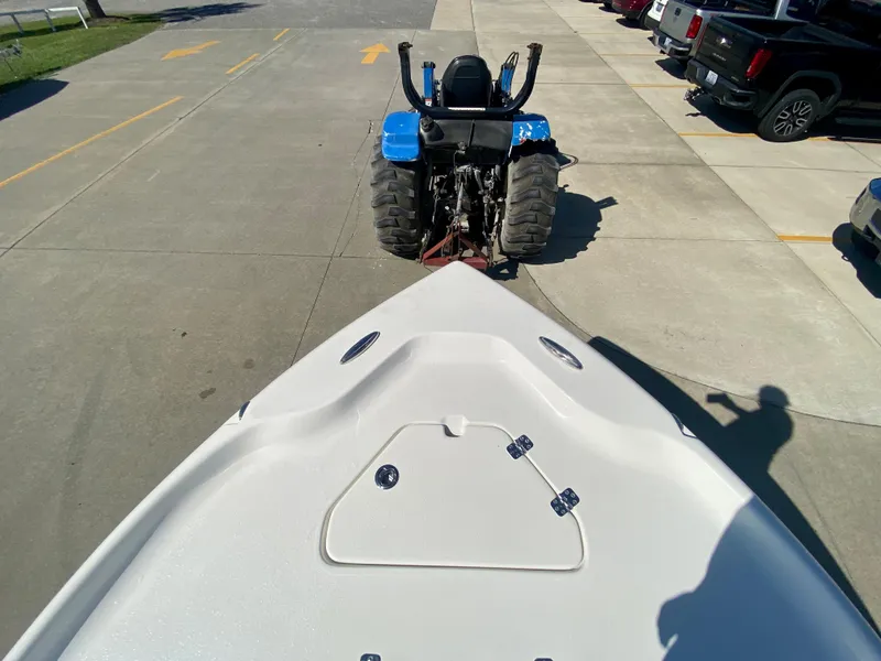 Slide: The Image of 2024 Key West 230 Bay Reef boat being towed by a blue tractor. - 28