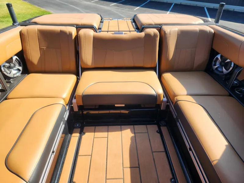 Slide: The Image of 2021 Malibu Wakesetter 24 MXZ interior with tan leather seating and built-in speakers. - 10