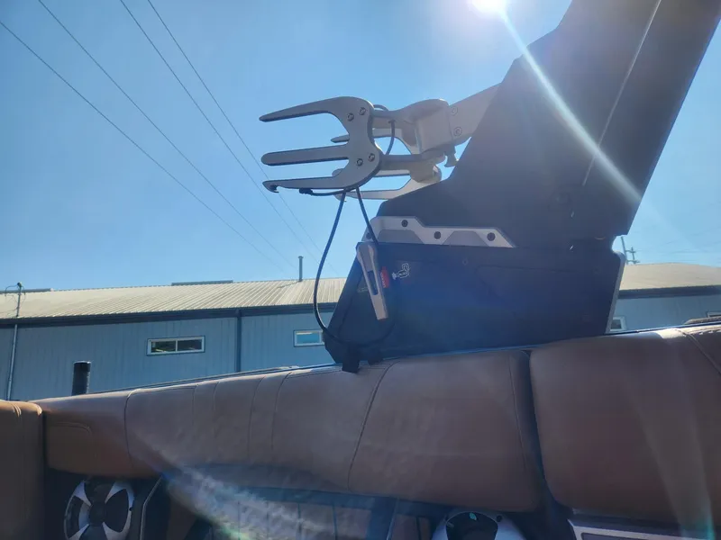 Slide: The Image of 2021 Malibu Wakesetter 24 MXZ boat interior with wakeboard rack under sunny sky. - 7