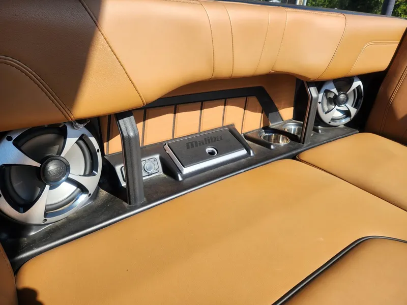 Slide: The Image of 2021 Malibu Wakesetter 24 MXZ interior with tan leather seats and built-in speakers. - 8