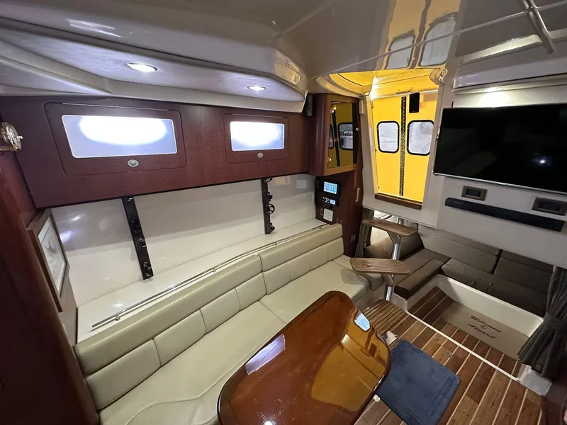 Slide: The Image of Interior of 2010 Boston Whaler 345 Conquest, featuring seating, table, and modern amenities. - 10