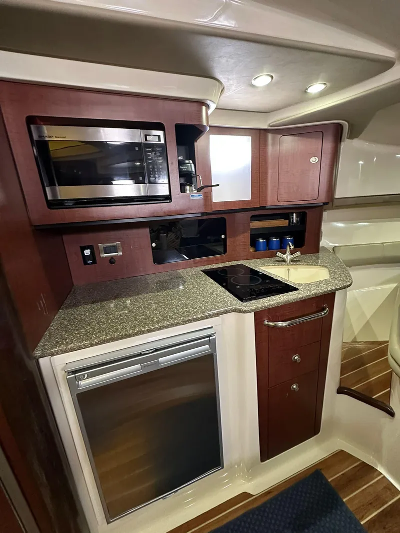 Slide: The Image of 2010 Boston Whaler 345 Conquest kitchen with microwave, stove, and fridge. - 11