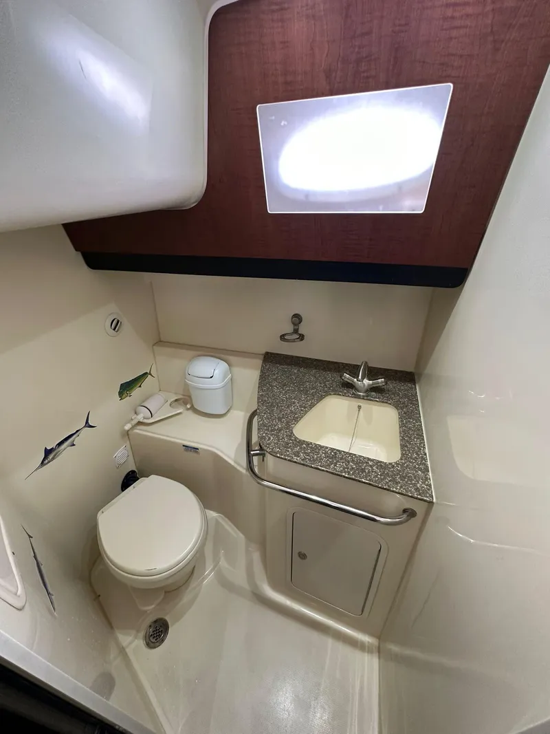 Slide: The Image of 2010 Boston Whaler 345 Conquest bathroom with toilet, sink, and countertop. - 13