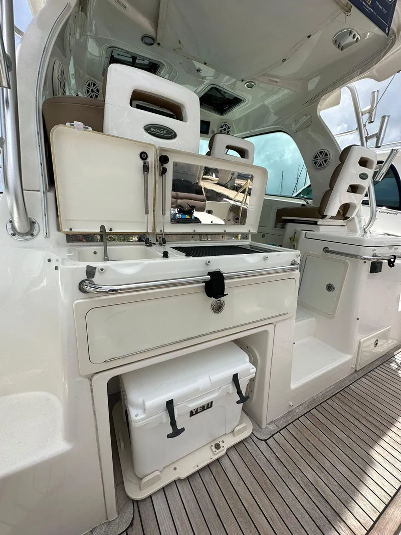 Slide: The Image of 2010 Boston Whaler 345 Conquest interior with seating and storage on deck. - 14