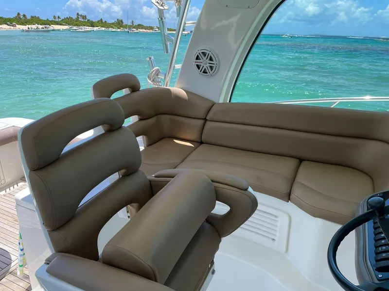 Slide: The Image of 2010 Boston Whaler 345 Conquest interior with plush seating, overlooking turquoise ocean waters. - 19