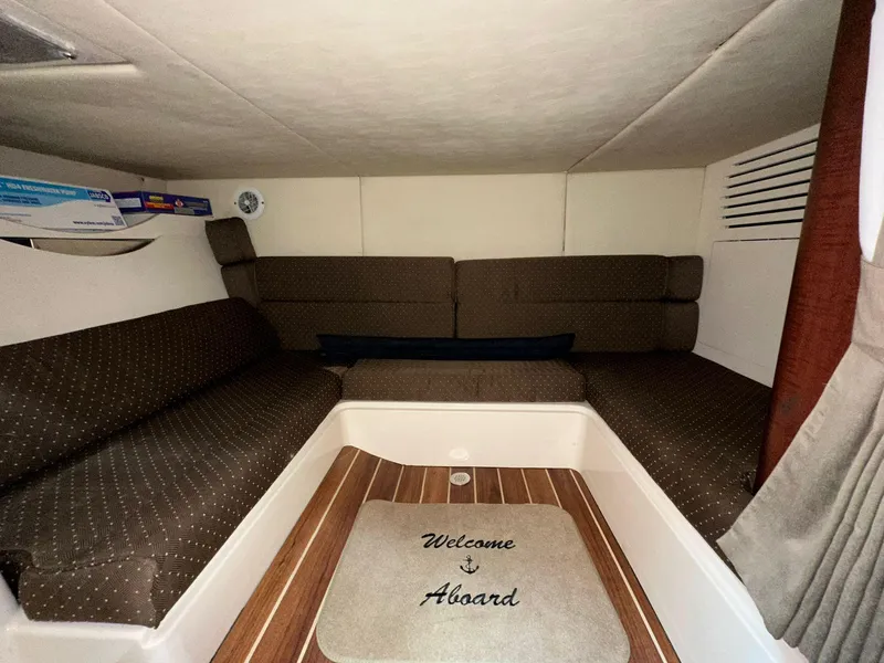 Slide: The Image of Interior cabin of 2010 Boston Whaler 345 Conquest with cozy seating and "Welcome Aboard" mat. - 22