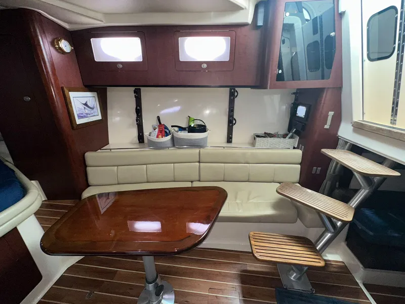 Slide: The Image of Interior of 2010 Boston Whaler 345 Conquest with wooden table and seating area. - 23
