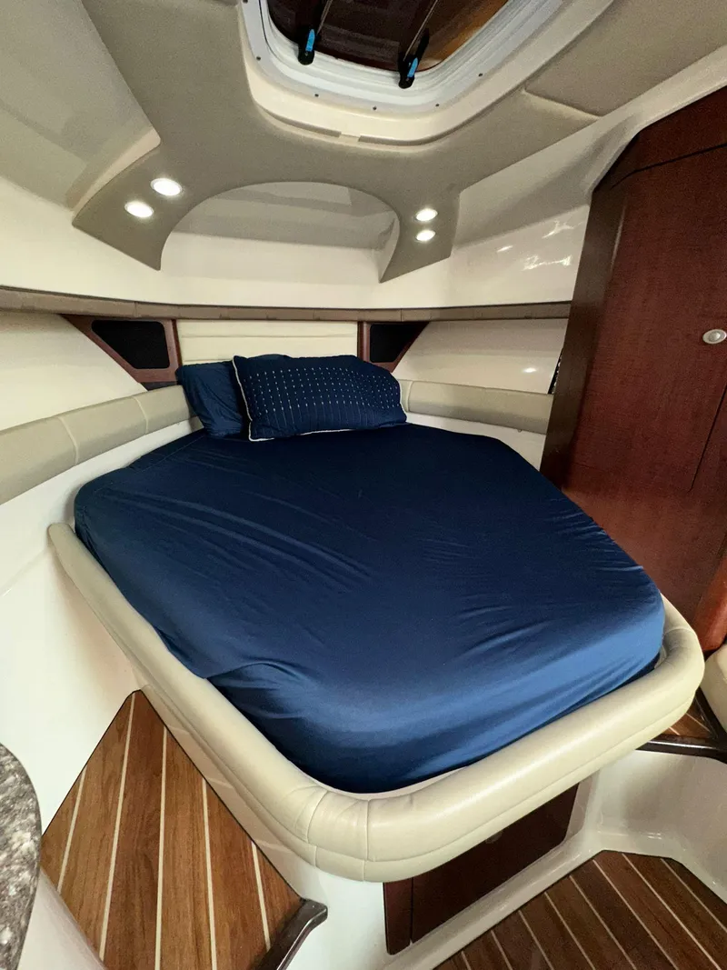 Slide: The Image of 2010 Boston Whaler 345 Conquest cabin with blue bedding and wooden accents. - 24