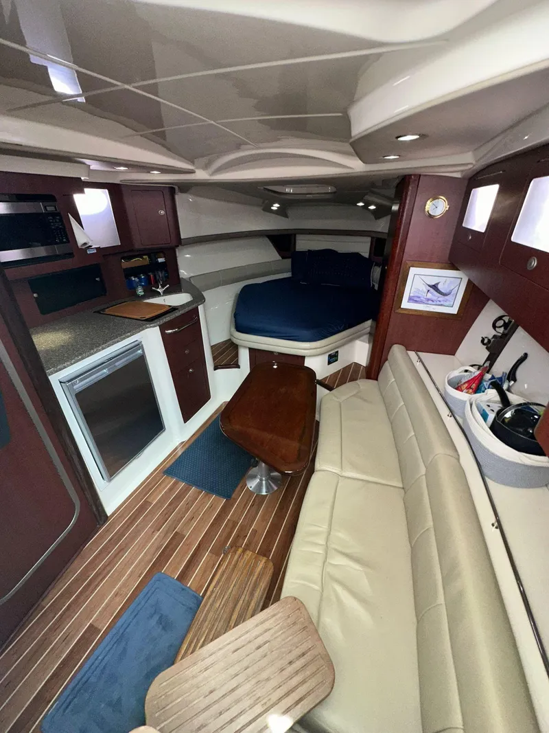 Slide: The Image of Interior of 2010 Boston Whaler 345 Conquest, featuring seating, kitchenette, and sleeping area. - 25
