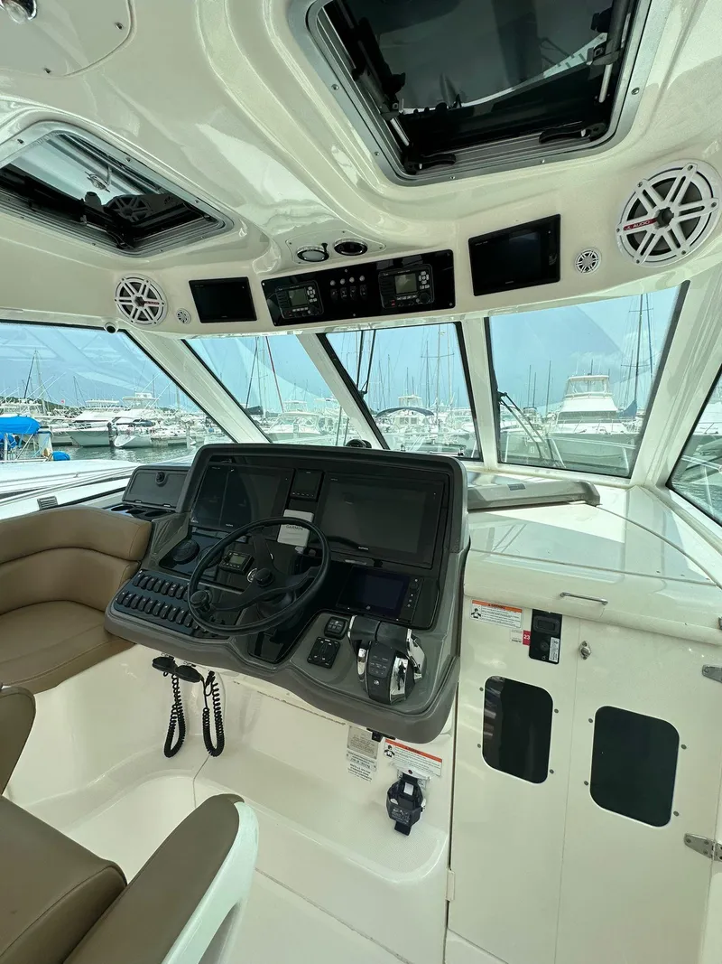 Slide: The Image of 2010 Boston Whaler 345 Conquest helm with modern controls and panoramic marina view. - 3