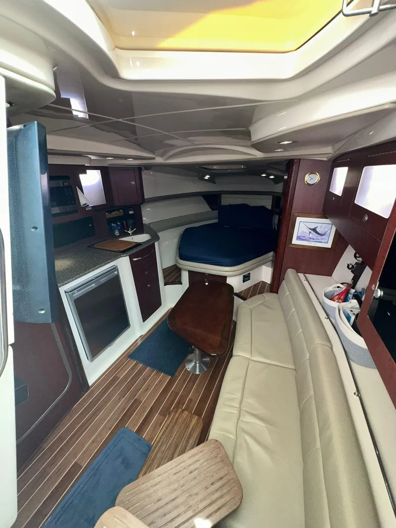 Slide: The Image of Interior of 2010 Boston Whaler 345 Conquest, featuring seating, table, and cabin amenities. - 7