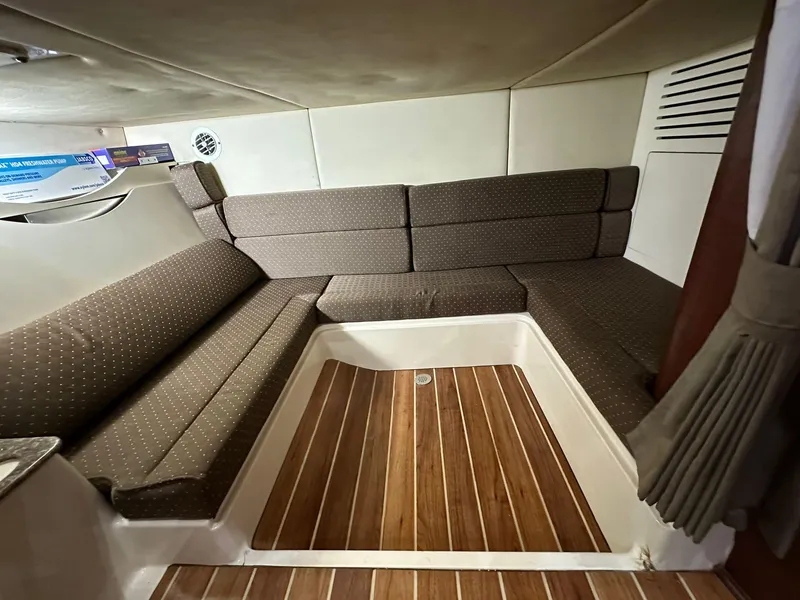 Slide: The Image of Interior cabin of 2010 Boston Whaler 345 Conquest with cushioned seating and wood flooring. - 8