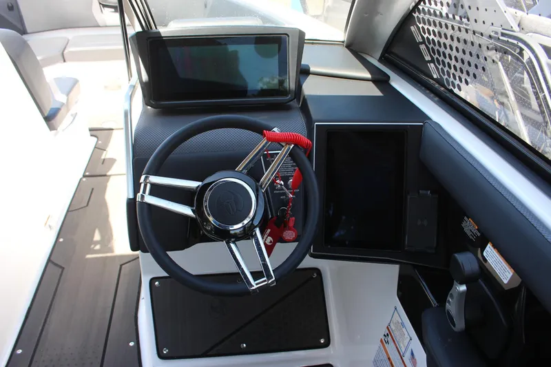 Slide: The Image of 2023 Scarab 285 ID boat cockpit with steering wheel and digital displays. - 10