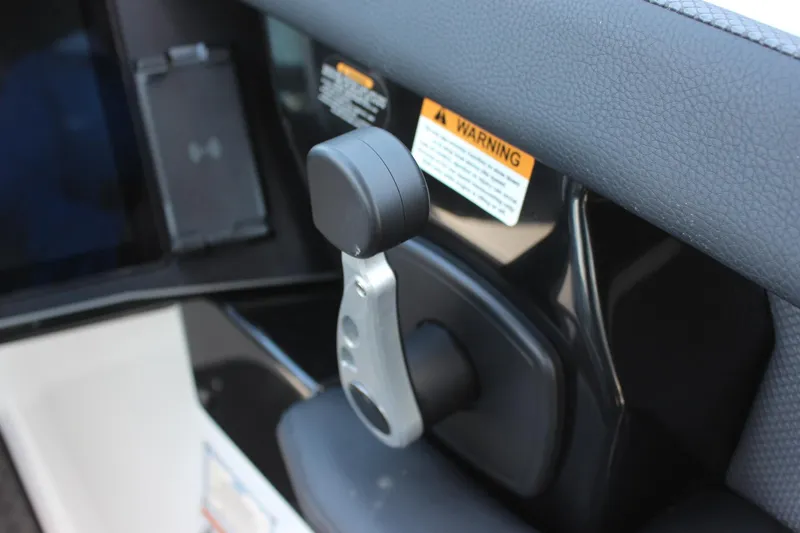 Slide: The Image of Throttle control of 2023 Scarab 285 ID boat with warning labels. - 12